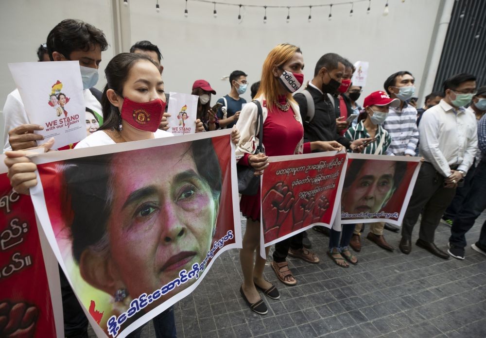 Bangkok : Myanmar nationals living in Thailand sing a song while holding images of deposed Myanmar leader Aung San Suu Kyi outside Mandalay Food House in Bangkok, Thailand, Friday, Feb. 5, 2021. AP/PTI